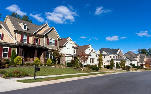 Street of large suburban homes on sunny day